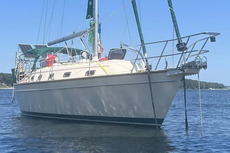 Ramble On Yacht Photos Pics Sailboat Island Packet 380, 2000 model, anchored on calm water with clear blue sky.