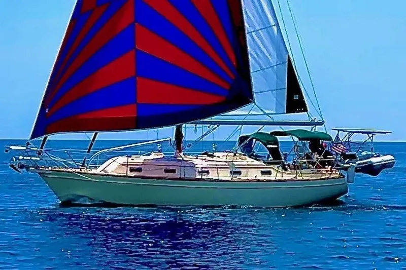 Ramble On Yacht Photos Pics Sailing yacht Island Packet 380, 2000 model, with vibrant red and blue sails on open water.