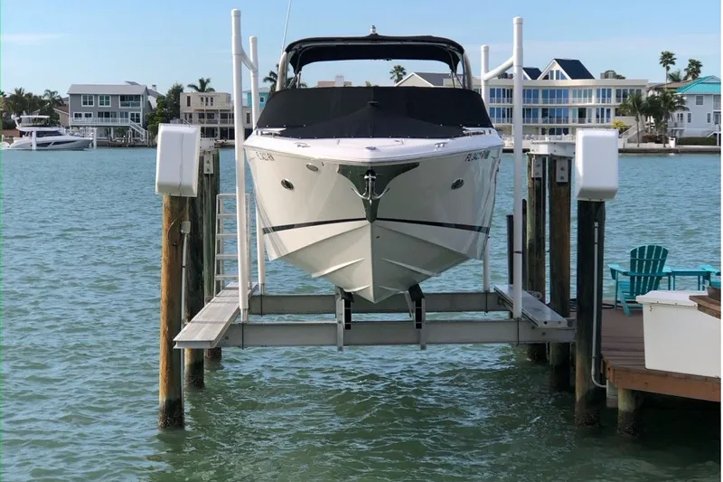  Yacht Photos Pics 2018 Regal 29 OBX boat on lift, docked by waterfront homes.