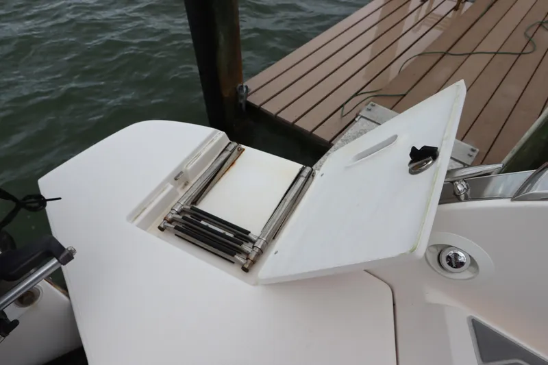 Yacht Photos Pics 2018 Regal 29 OBX boat with foldable swim ladder near dock.