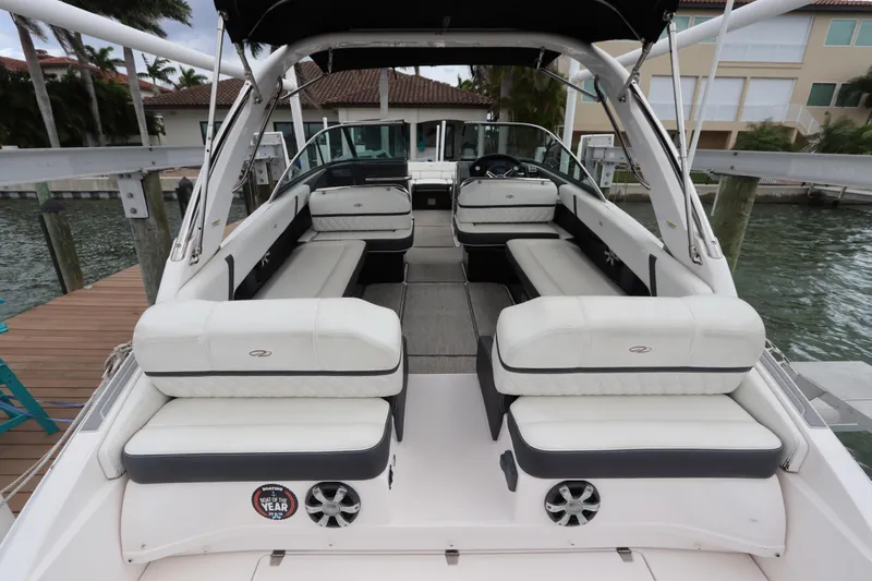  Yacht Photos Pics 2018 Regal 29 OBX boat interior with white seating, docked by waterfront homes.