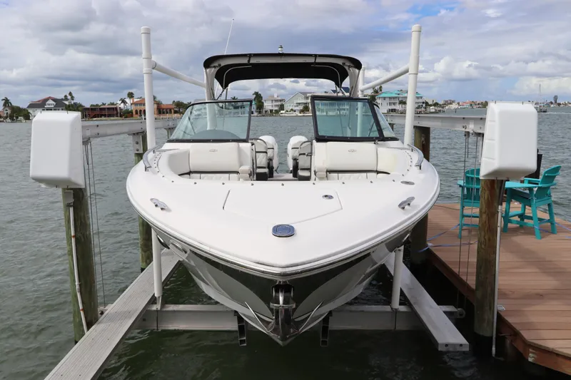  Yacht Photos Pics 2018 Regal 29 OBX boat docked on a lift by waterfront homes.