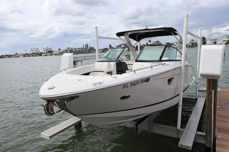  Yacht Photos Pics 2018 Regal 29 OBX boat docked on a lift, with scenic waterfront background.