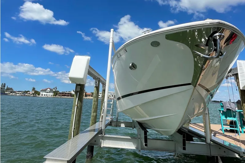  Yacht Photos Pics 2018 Regal 29 OBX boat on lift, clear sky, waterfront view.