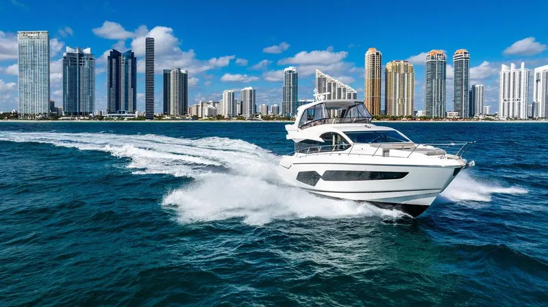 My Inspiration Yacht Photos Pics 2019 Sunseeker Manhattan 66 yacht cruising near city skyline on a sunny day.