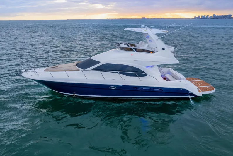 One Love Yacht Photos Pics 2006 Sea Ray 44 Sedan Bridge yacht cruising on open water at sunset.