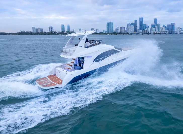 One Love Yacht Photos Pics 2006 Sea Ray 44 Sedan Bridge yacht cruising near city skyline.