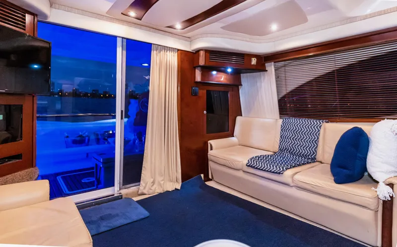 One Love Yacht Photos Pics Luxurious interior of 2006 Sea Ray 44 Sedan Bridge yacht with cozy seating and ambient lighting.