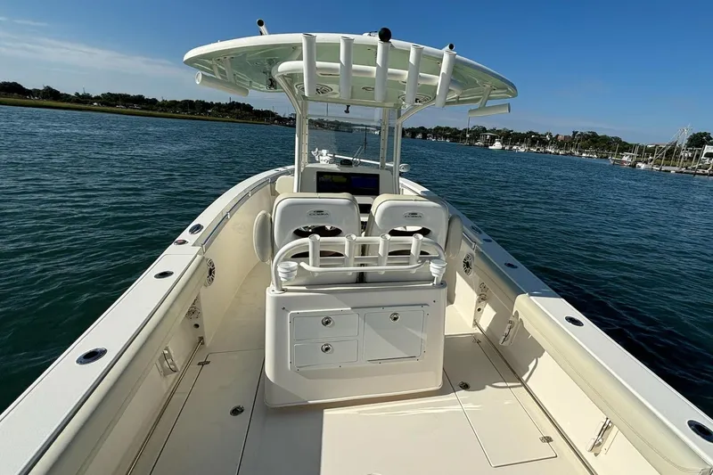  Yacht Photos Pics 2020 Cobia 280 Center Console boat on calm water, featuring spacious deck and seating.