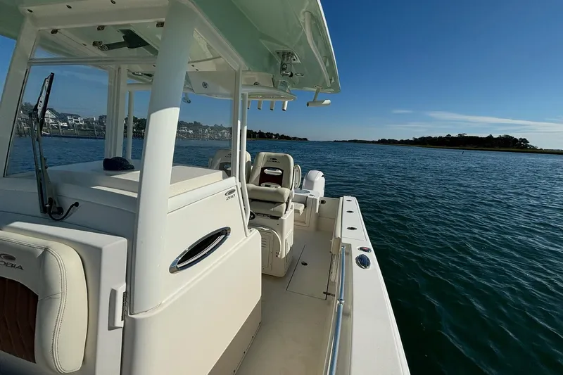  Yacht Photos Pics 2020 Cobia 280 Center Console boat on calm water under clear blue sky.