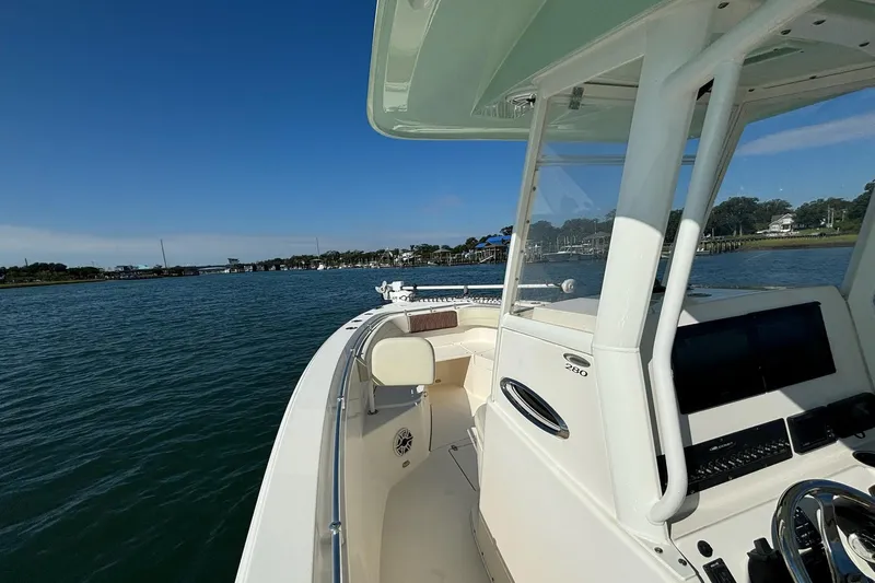  Yacht Photos Pics 2020 Cobia 280 Center Console boat cruising on a sunny day near the shoreline.