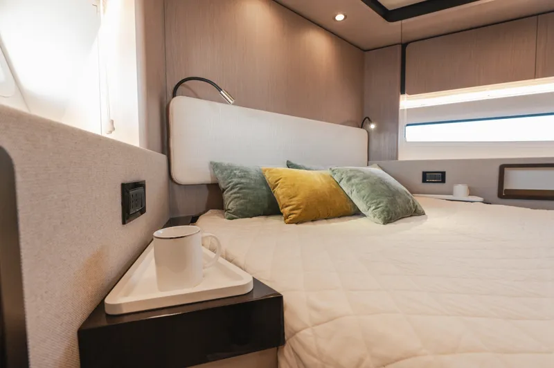  Yacht Photos Pics Luxurious bedroom interior of 2023 Azimut 72 Flybridge yacht with cozy bedding and modern decor.