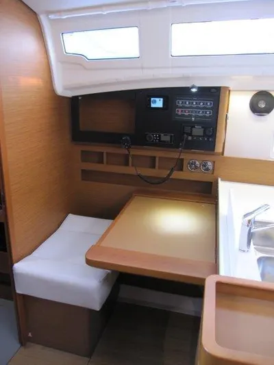  Yacht Photos Pics 2024 Jeanneau Sun Odyssey 410 interior with navigation station and seating area.