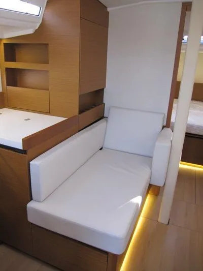  Yacht Photos Pics 2024 Jeanneau Sun Odyssey 410 interior with modern seating and wooden cabinetry.