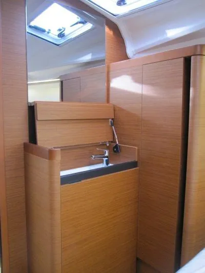  Yacht Photos Pics 2024 Jeanneau Sun Odyssey 410 interior with modern wood finish and compact sink area.