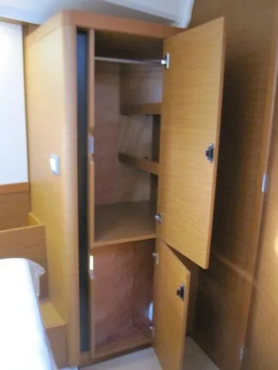  Yacht Photos Pics 2024 Jeanneau Sun Odyssey 410 interior wooden storage cabinet with open doors.
