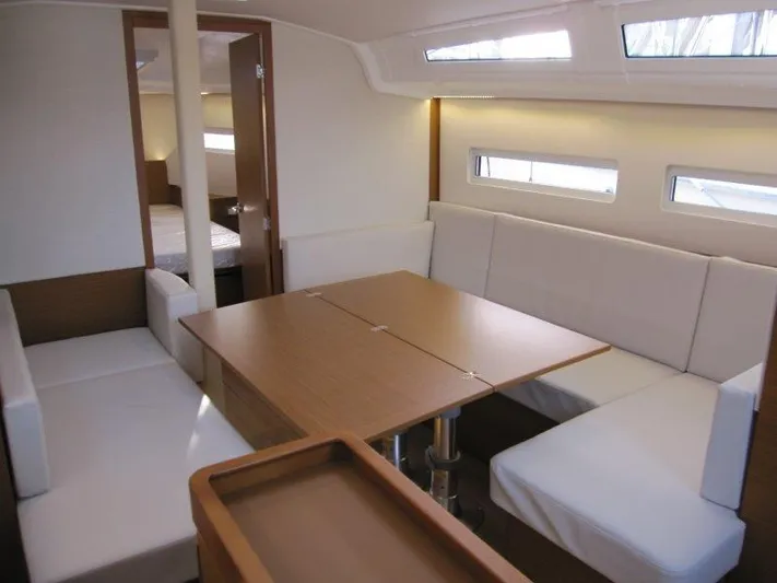  Yacht Photos Pics 2024 Jeanneau Sun Odyssey 410 interior with modern seating and dining area.