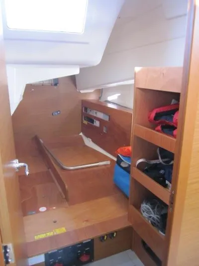  Yacht Photos Pics 2024 Jeanneau Sun Odyssey 410 cabin interior with wooden storage and seating area.