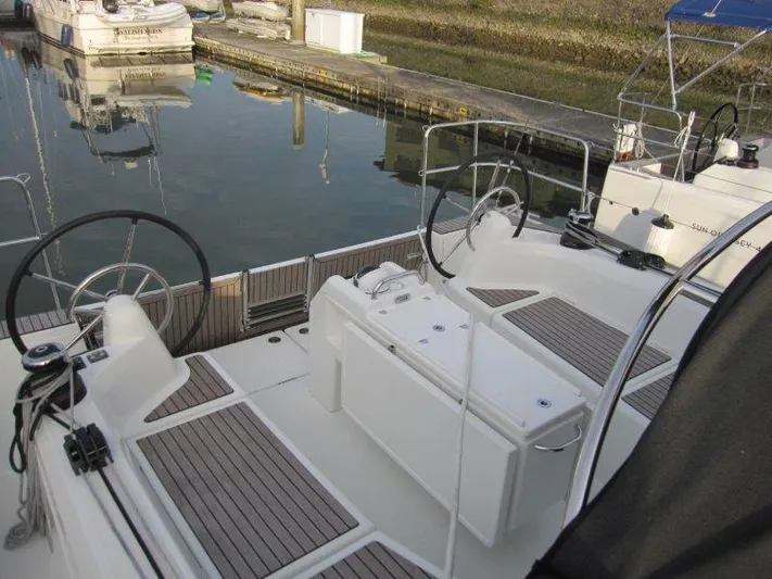  Yacht Photos Pics 2024 Jeanneau Sun Odyssey 410 sailboat cockpit with dual steering wheels, docked at marina.
