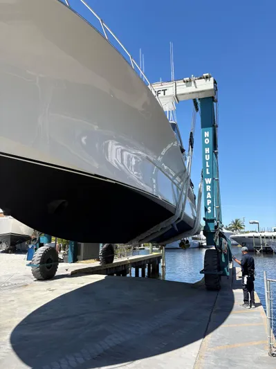  Yacht Photos Pics Buddy Davis 78 yacht being lifted at a marina, clear blue sky.