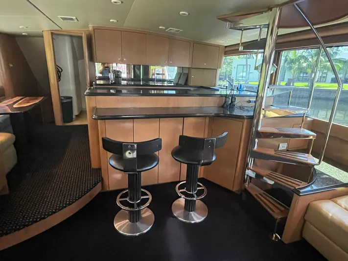  Yacht Photos Pics Luxurious interior of 2000 Buddy Davis 78 yacht with modern bar and spiral staircase.