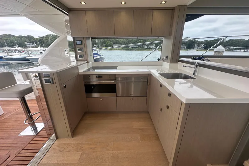  Yacht Photos Pics Luxurious 2018 Sunseeker Manhattan 52 yacht kitchen with modern appliances and scenic marina view.