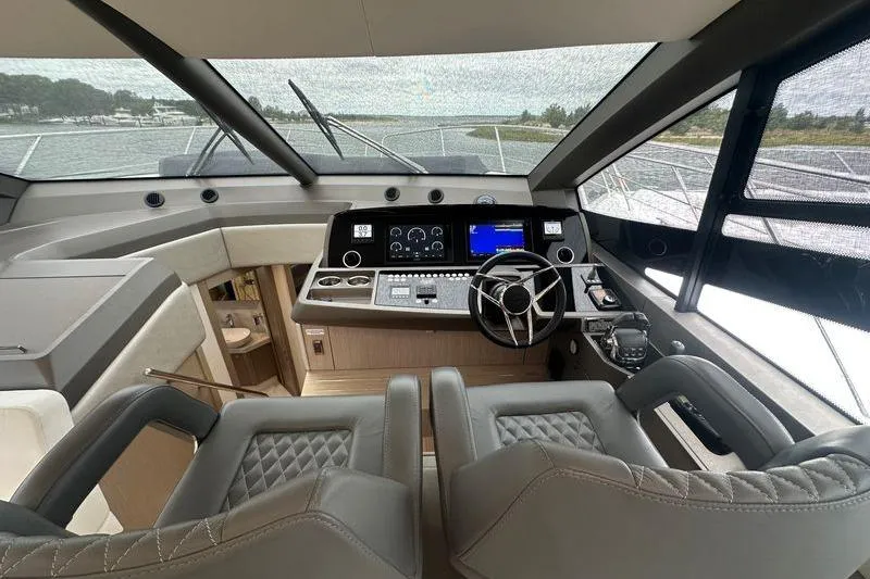  Yacht Photos Pics Interior cockpit of 2018 Sunseeker Manhattan 52 yacht with modern controls and seating.