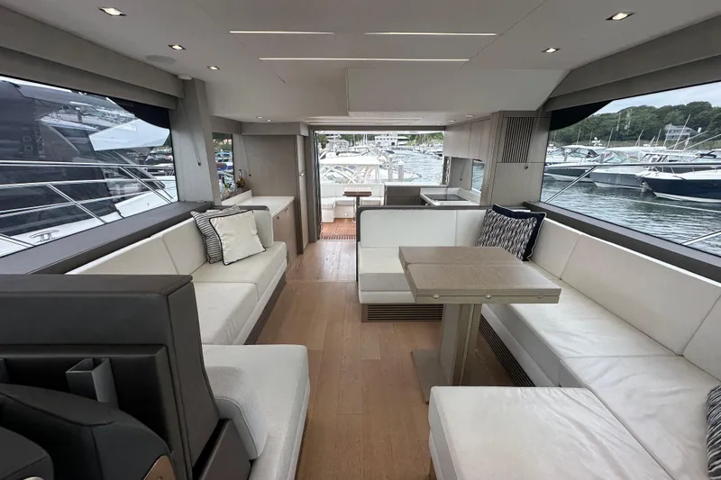  Yacht Photos Pics Luxurious interior of 2018 Sunseeker Manhattan 52 yacht with elegant seating and scenic marina view.