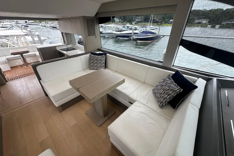  Yacht Photos Pics Luxurious interior of 2018 Sunseeker Manhattan 52 yacht with elegant seating and scenic marina view.