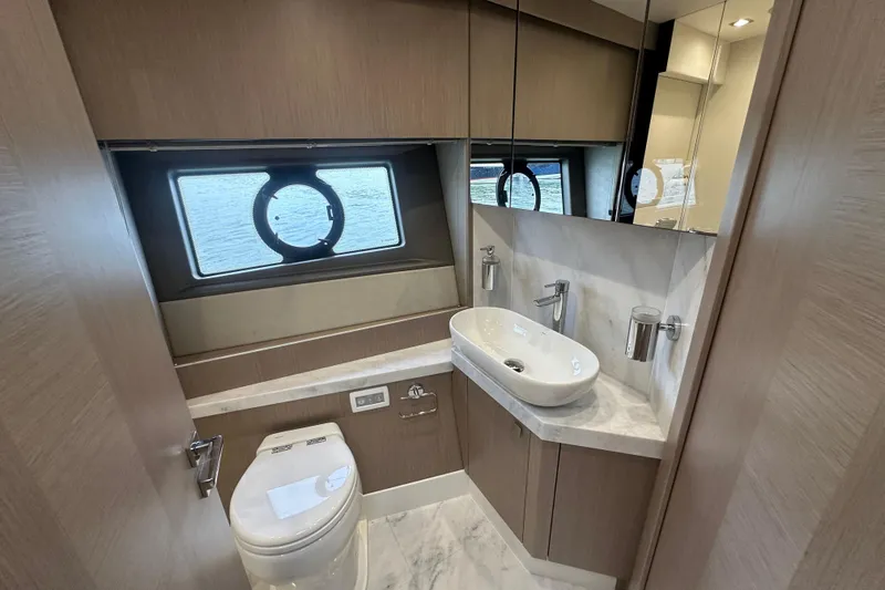  Yacht Photos Pics Luxurious bathroom in 2018 Sunseeker Manhattan 52 yacht with modern fixtures and porthole window.