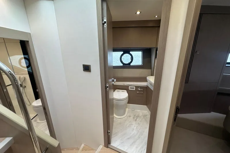  Yacht Photos Pics Interior of 2018 Sunseeker Manhattan 52 yacht, featuring a modern bathroom with porthole window.