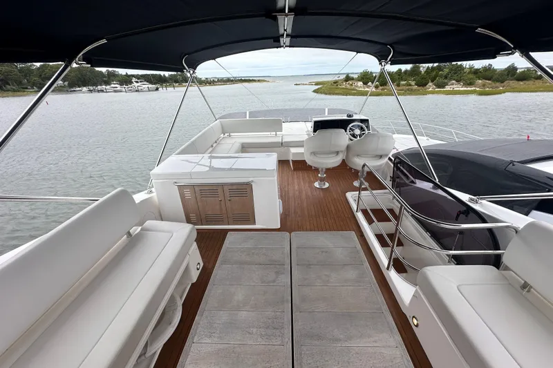  Yacht Photos Pics Luxurious 2018 Sunseeker Manhattan 52 yacht interior with elegant seating and helm, docked by serene waters.