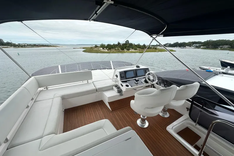  Yacht Photos Pics Flybridge of 2018 Sunseeker Manhattan 52 yacht with seating and helm, overlooking serene waters.