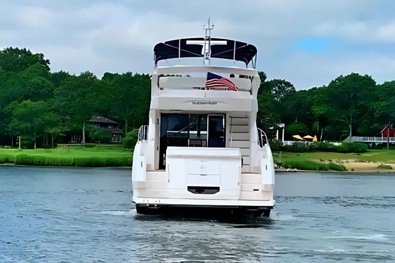  Yacht Photos Pics 2018 Sunseeker Manhattan 52 yacht on a serene waterway with lush greenery.