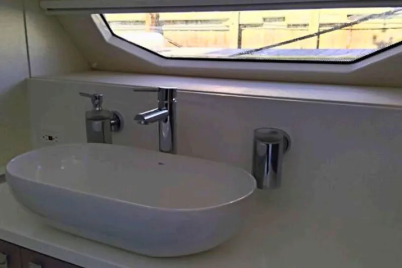  Yacht Photos Pics Modern bathroom sink in 2018 Sunseeker Manhattan 52 yacht, featuring sleek design and window view.
