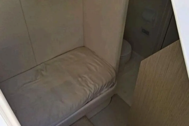  Yacht Photos Pics Interior cabin of 2018 Sunseeker Manhattan 52 yacht, featuring a compact bed and bathroom.