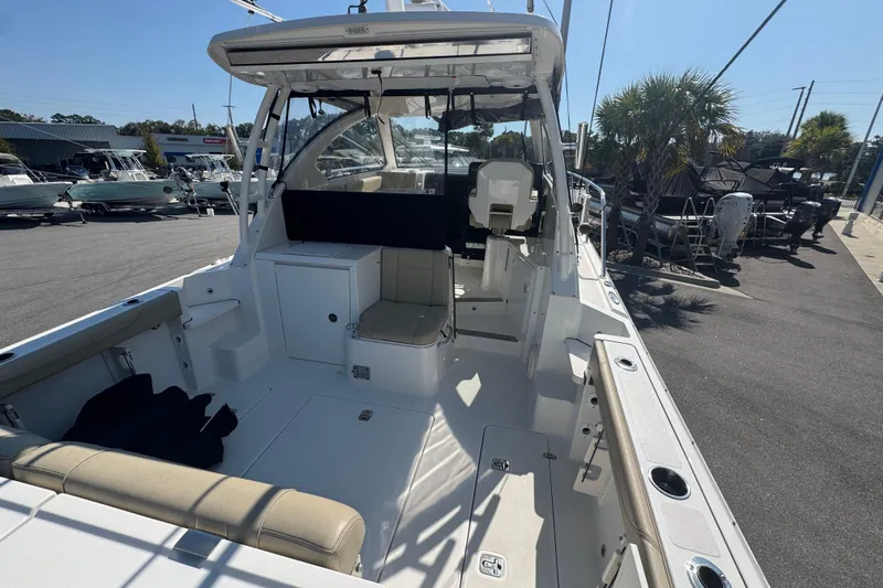  Yacht Photos Pics 2020 Pursuit OS 325 Offshore boat interior with seating and helm, docked under clear sky.