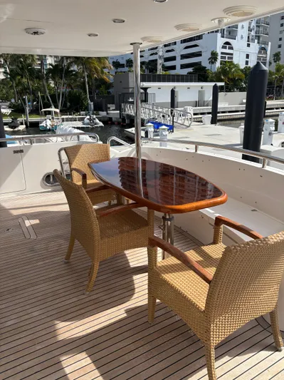 Arlene Yacht Photos Pics Outdoor seating on a 2009 Horizon Vision 74 yacht with wicker chairs and wooden table.
