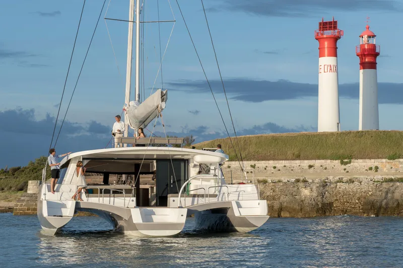 Dauntless Yacht Photos Pics NEEL 51 trimaran sailing near two lighthouses, 2022 model.