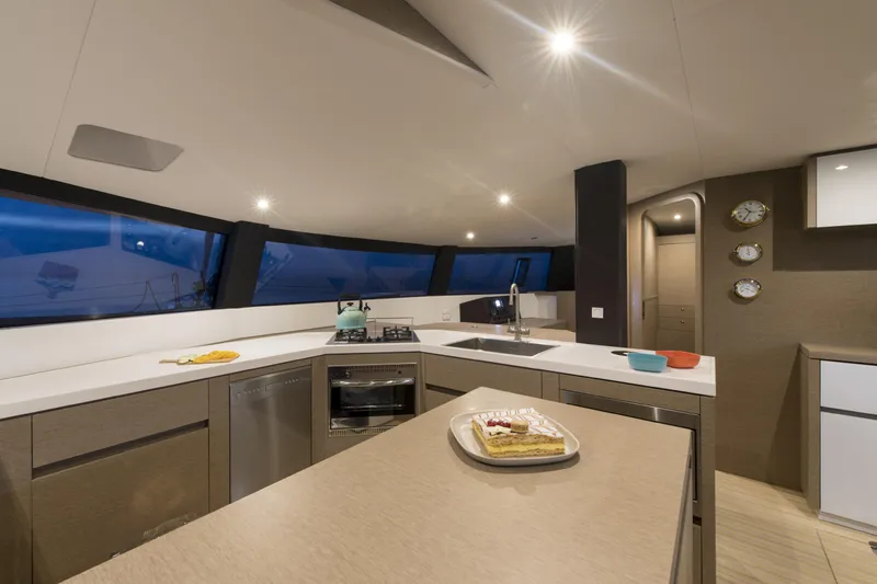 Dauntless Yacht Photos Pics Modern kitchen interior on NEEL 51 trimaran, 2022 model, featuring sleek countertops and appliances.