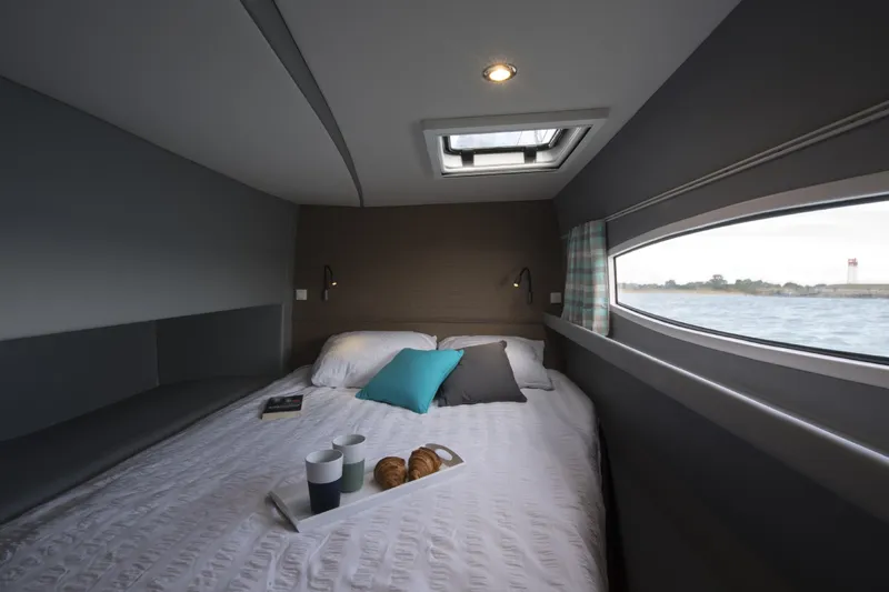 Dauntless Yacht Photos Pics Cozy cabin interior of 2022 NEEL 51 with bed, skylight, and ocean view.