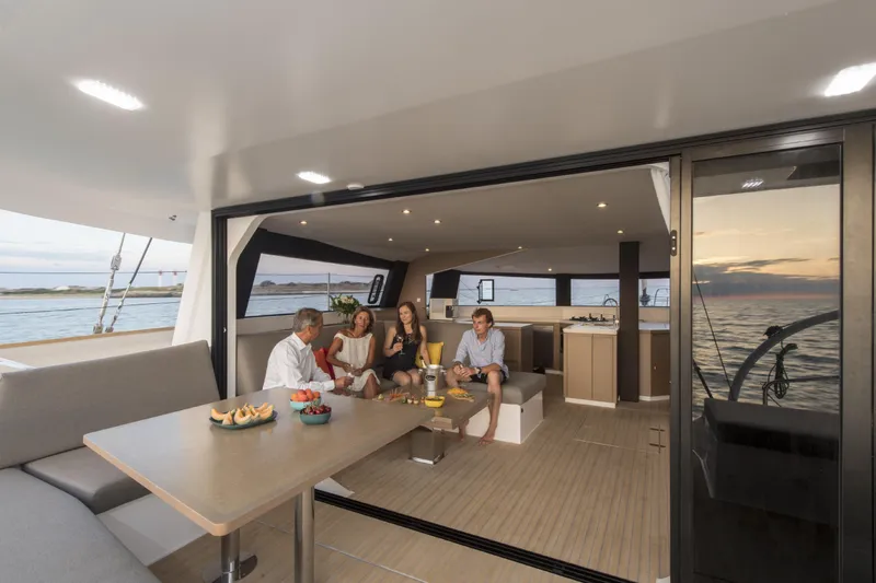 Dauntless Yacht Photos Pics Luxurious NEEL 51 yacht interior with people enjoying a meal, 2022 model.