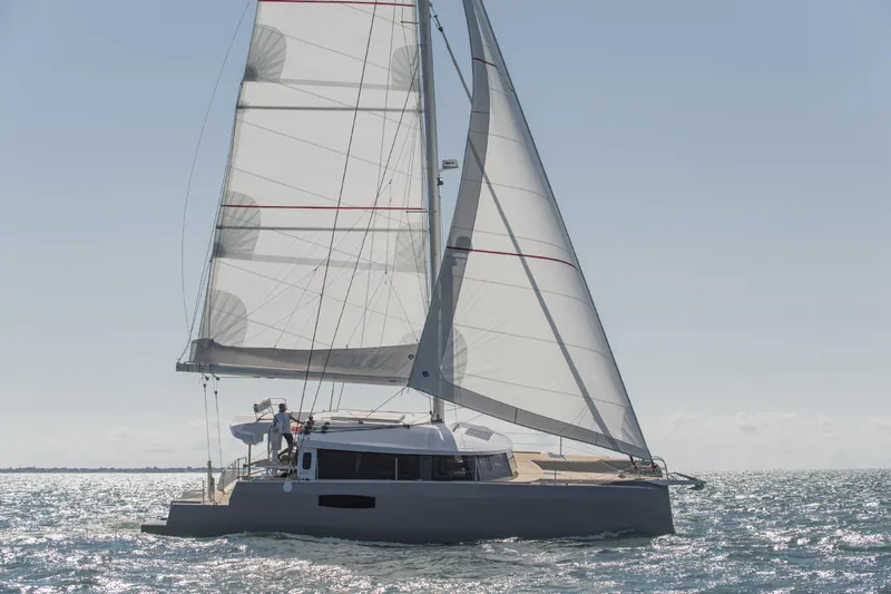 Dauntless Yacht Photos Pics Trimaran sailing on open water, NEEL 51 model, 2022, with full sails under clear sky.