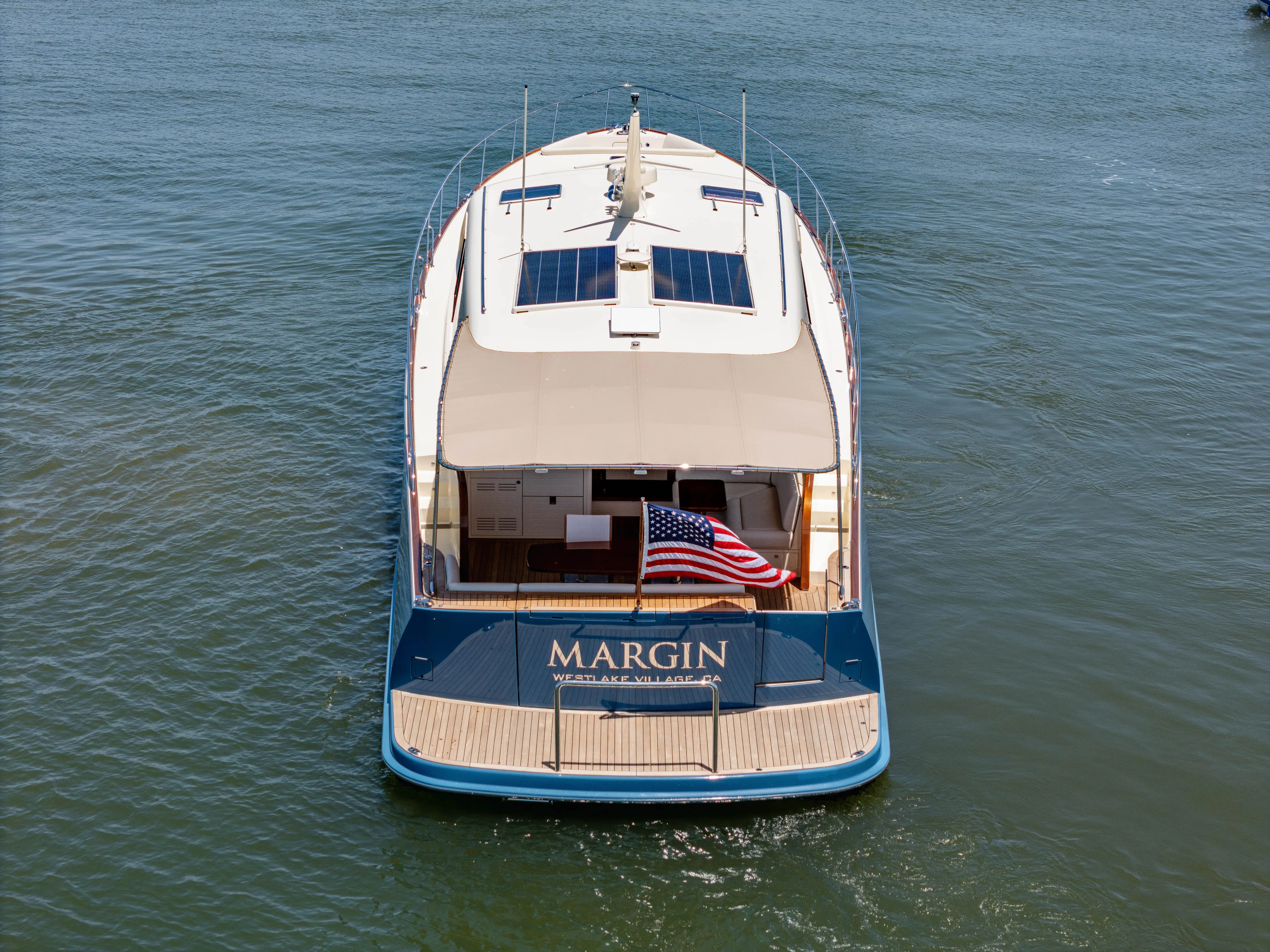 Margin Yacht Photos Pics 2025 Palm Beach Motor Yachts PB70 on water, rear view with American flag.