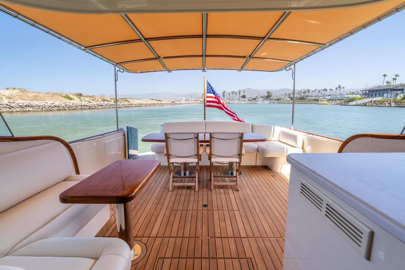 Margin Yacht Photos Pics Luxurious 2025 Palm Beach Motor Yachts PB70 deck with seating, table, and American flag.