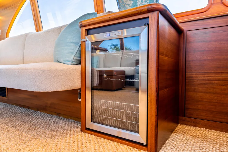 Margin Yacht Photos Pics Luxurious interior of 2025 Palm Beach Motor Yachts PB70 with elegant wood finish and mini fridge.