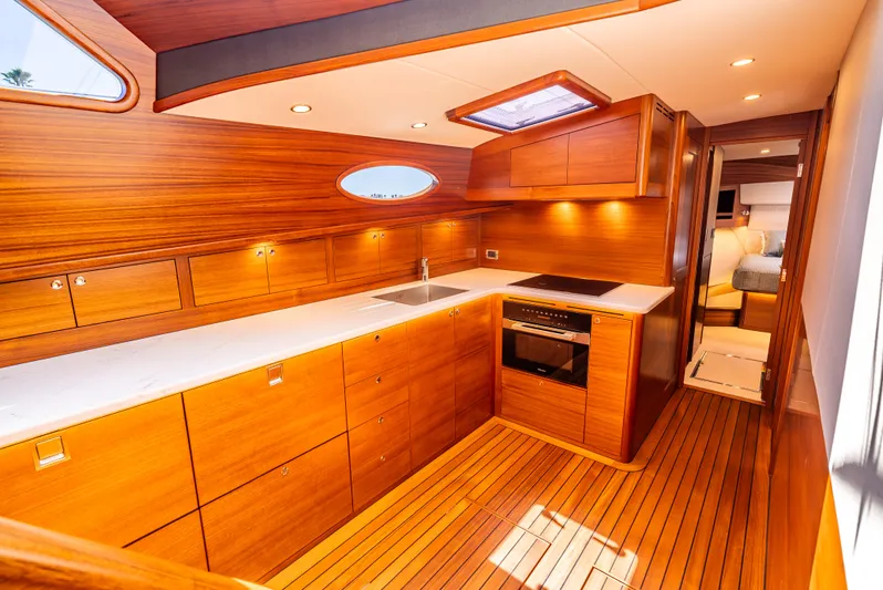 Margin Yacht Photos Pics Luxurious 2025 Palm Beach Motor Yachts PB70 kitchen with wood finish and modern appliances.