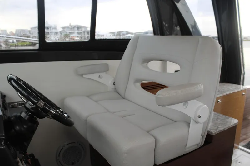 Dream Weaver Yacht Photos Pics Captain's seat in 2021 Ocean Alexander 45 Divergence Coupe, featuring luxurious white upholstery.