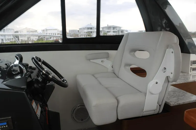 Dream Weaver Yacht Photos Pics Interior of 2021 Ocean Alexander 45 Divergence Coupe with steering wheel and white captain's seat.