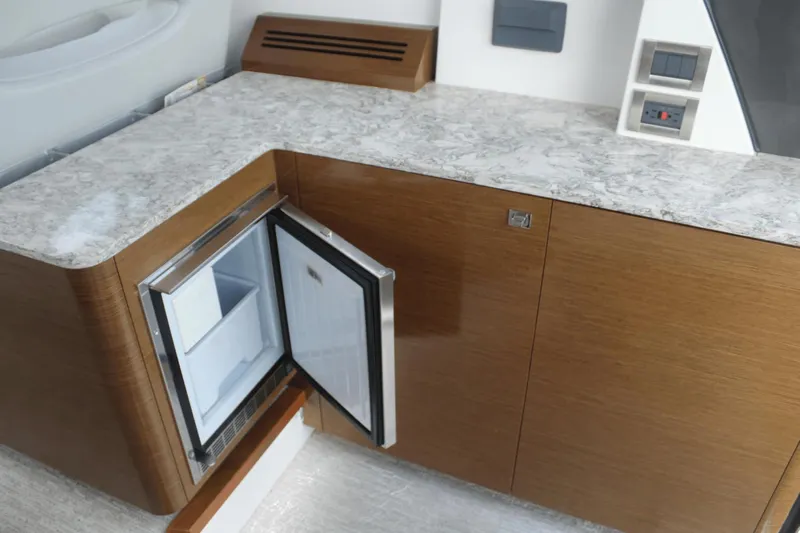 Dream Weaver Yacht Photos Pics 2021 Ocean Alexander 45 Divergence Coupe interior with open mini fridge and marble countertop.